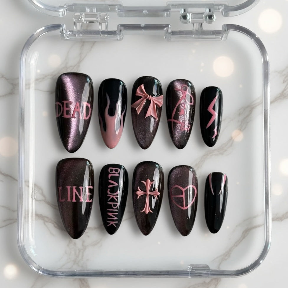 Set of black and pink nail art designs in a clear case on a marble background
