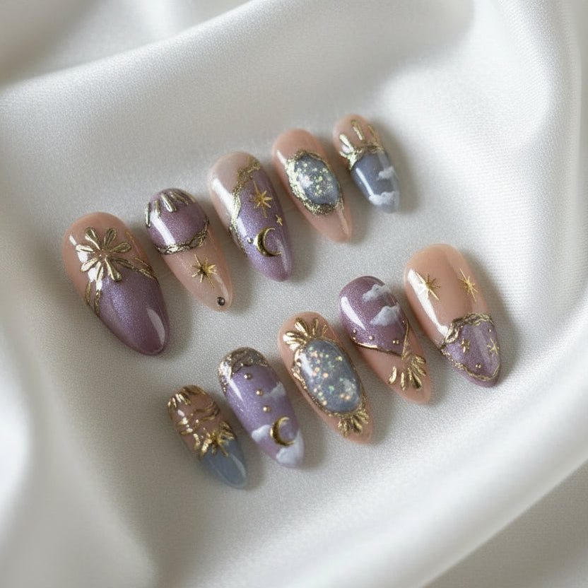Set of decorative false nails with purple and gold designs in a clear case.