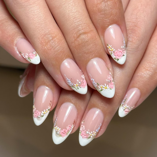 Close-up of hands with floral nail design on a neutral background