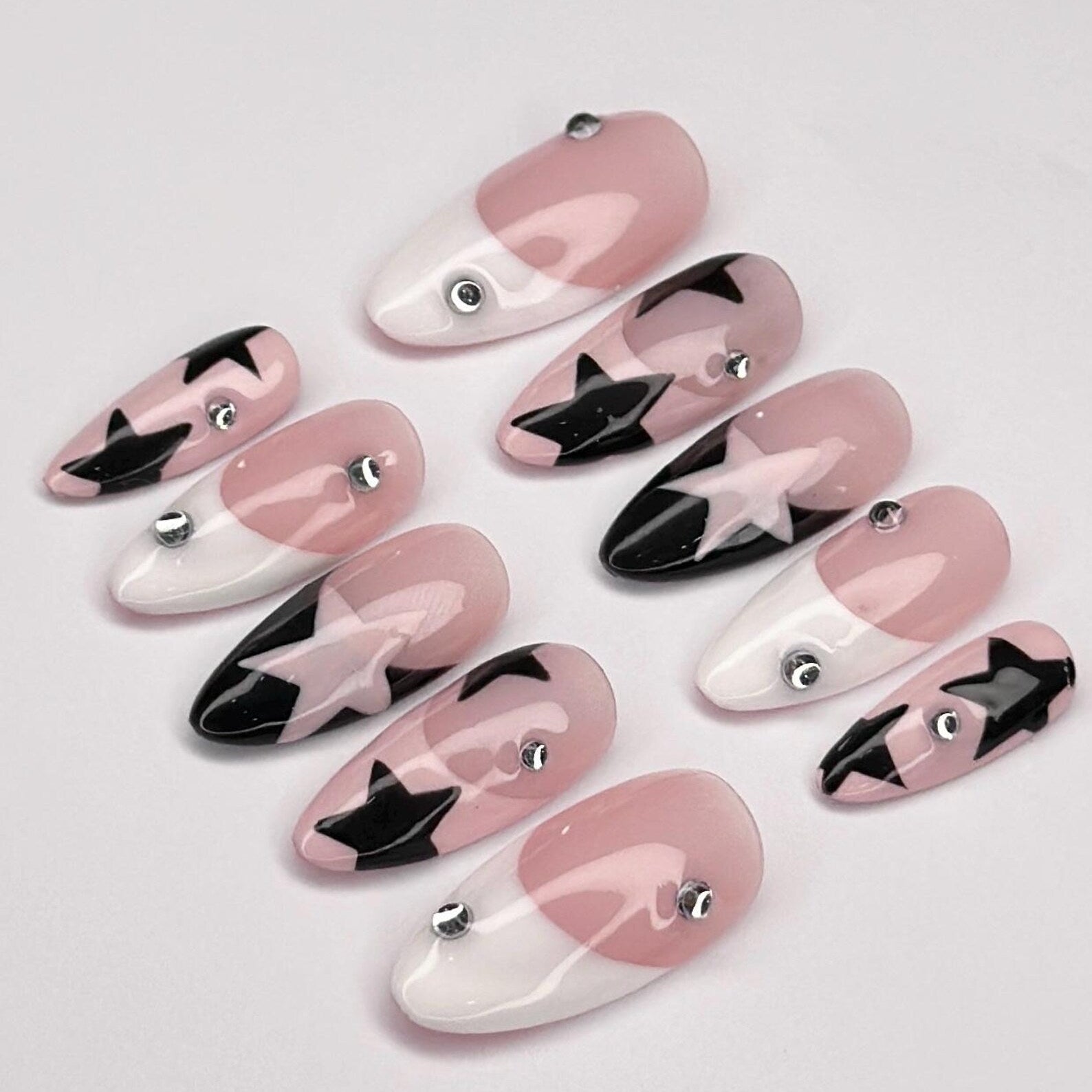 Set of pink, black, and white nail art designs on a light gray background
