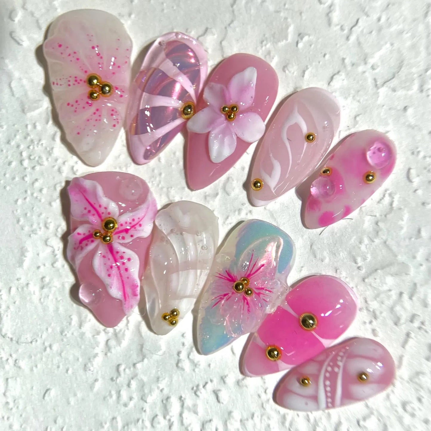Pink butterfly-shaped decorative items with gold accents on a textured white background