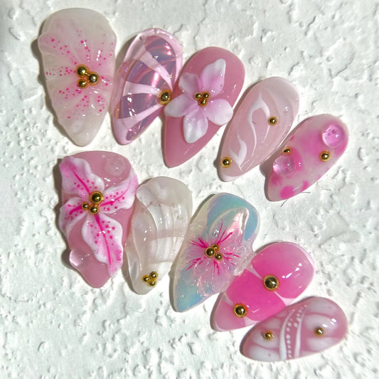 Pink butterfly-shaped decorative items with gold accents on a textured white background