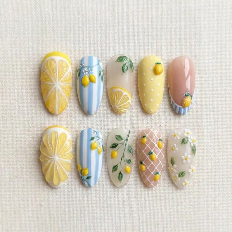 Decorative nail art with lemon and floral designs on a textured surface